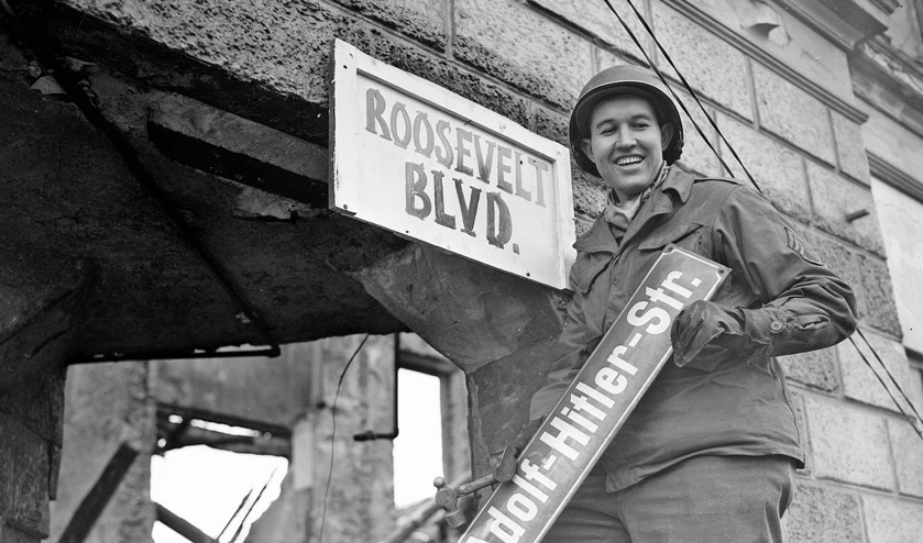 Een Amerikaanse militair maakt korte metten met de Hitler-cultus in het Duitse stadje Krefeld. (National Archives and Record Administration)