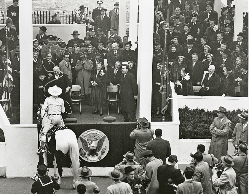 De pas aangetreden president Eisenhower laat zich vangen met een lasso. Links van de rechterzuil staat vicepresident Richard Nixon. De vrouw met corsage is mevrouw Eisenhower. (eisenhower presidential library)