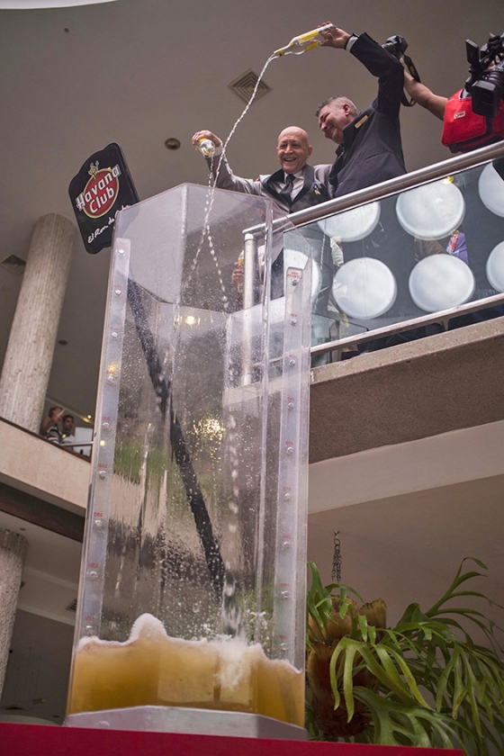 Barmannen vullen een gigantisch glas met rum voor een wereldrecordpoging Cuba Libre maken in Havane. De Cubaanse ‘supercocktail’ bevatte onder andere 192 flessen rum en 350 liter frisdrank. (ap / Desmond Boylan)