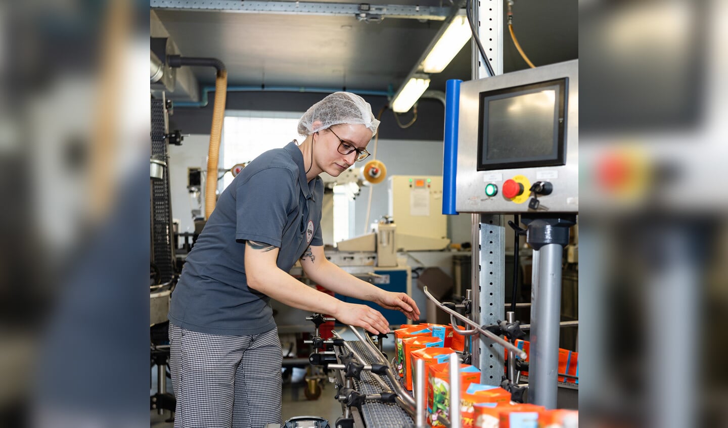 Een medewerker van matzesfabriek Hollandia in Enschede bij de typerende oranje matzesdoosjes.