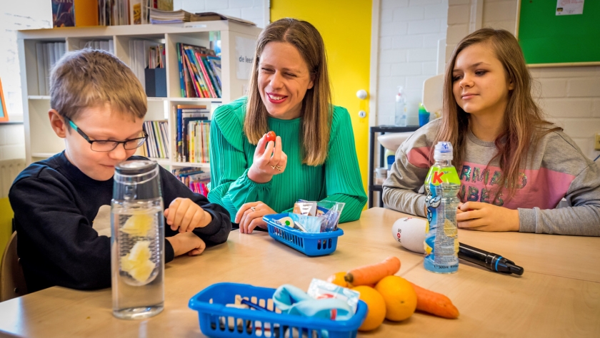 Minister Carola Schouten van Landbouw, Natuur en Voedselkwaliteit deelt fruit uit op basisschool De Springbok in Den Haag. (anp / Lex van Lieshout)
