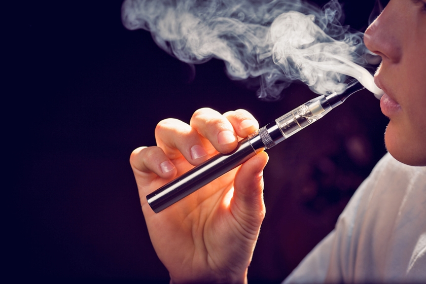 Een vrouw rookt een e-sigaret. Uit steeds meer studies blijkt dat ‘e-roken’ een opstapje kan zijn naar ‘gewoon’ roken. (istock)