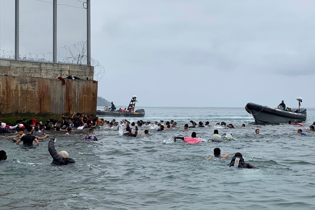 2021-05-18 06:33:41 epa09208440 Hundreds of people try to swim from Fnideq (Morocco) to Ceuta, Spanish enclave in the north frica, 18 May 2021, as Spanish army troops are deployed after a total of 5,000 Moroccan nationals managed to entry the city by sea during the night and hundreds continue to arrive. EPA/MOHAMED SIALI (beeld Epa/mohamed Siali)