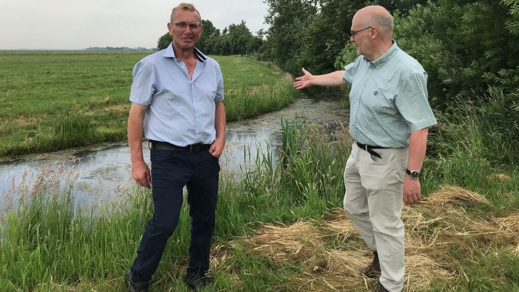 Veehouder Dick Laan, voorzitter van de vereniging Rietveldse kade, en Bernard de Jong van het hoogheemraadschap bekijken de schade. (beeld RTV Utrecht)