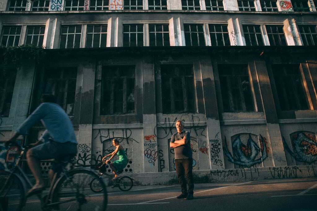 SLOVENIE Verhaal over de uitgewisten (Rosa van Gool) - Op de foto: Irfan Beširevic, in de achtergrond ROG, een oude fabriek en voormalig cultureel centrum (beeld Marlena Waldthausen)