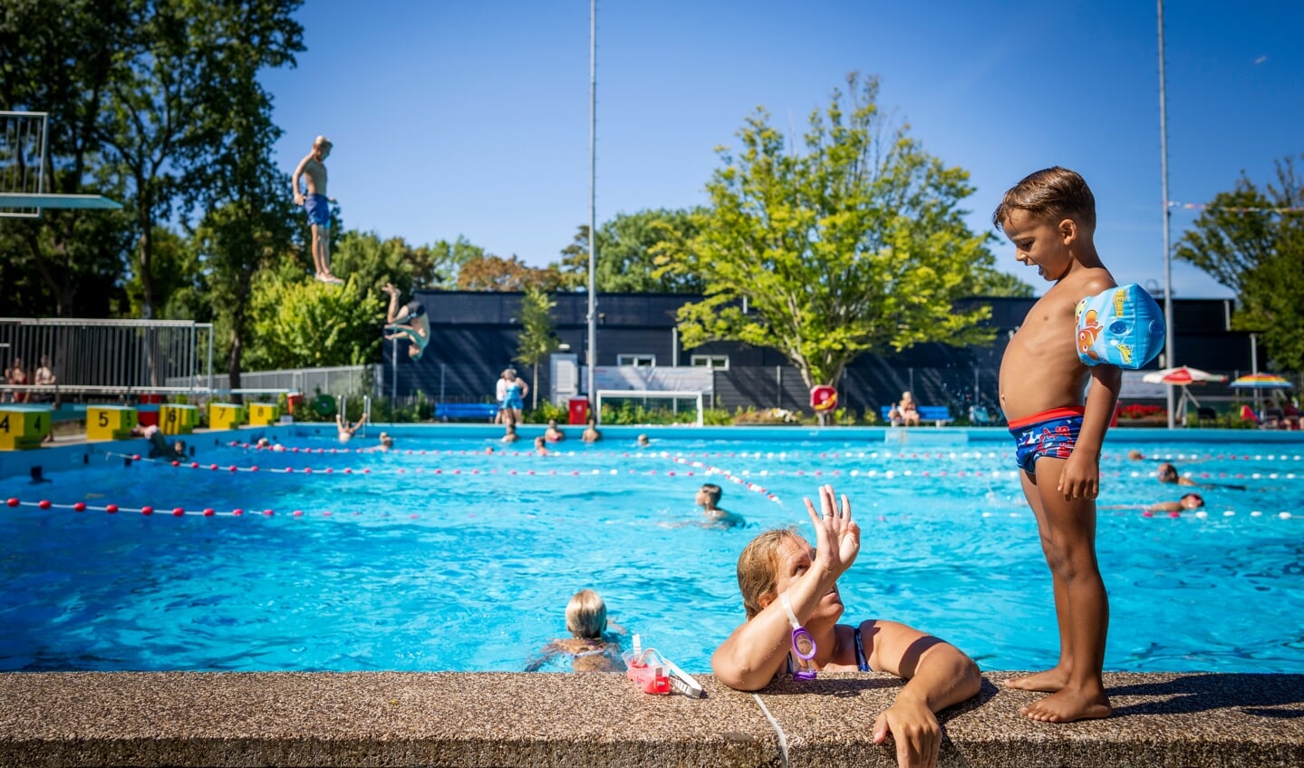 09-08-2022 LEIDEN - Badgasten in het zwembad (namen bekend bij de verslaggever). Zwembad de Vliet in Leiden maakt gebruik van een systeem dat zout omzet in chloor. FREEK VAN DEN BERGH