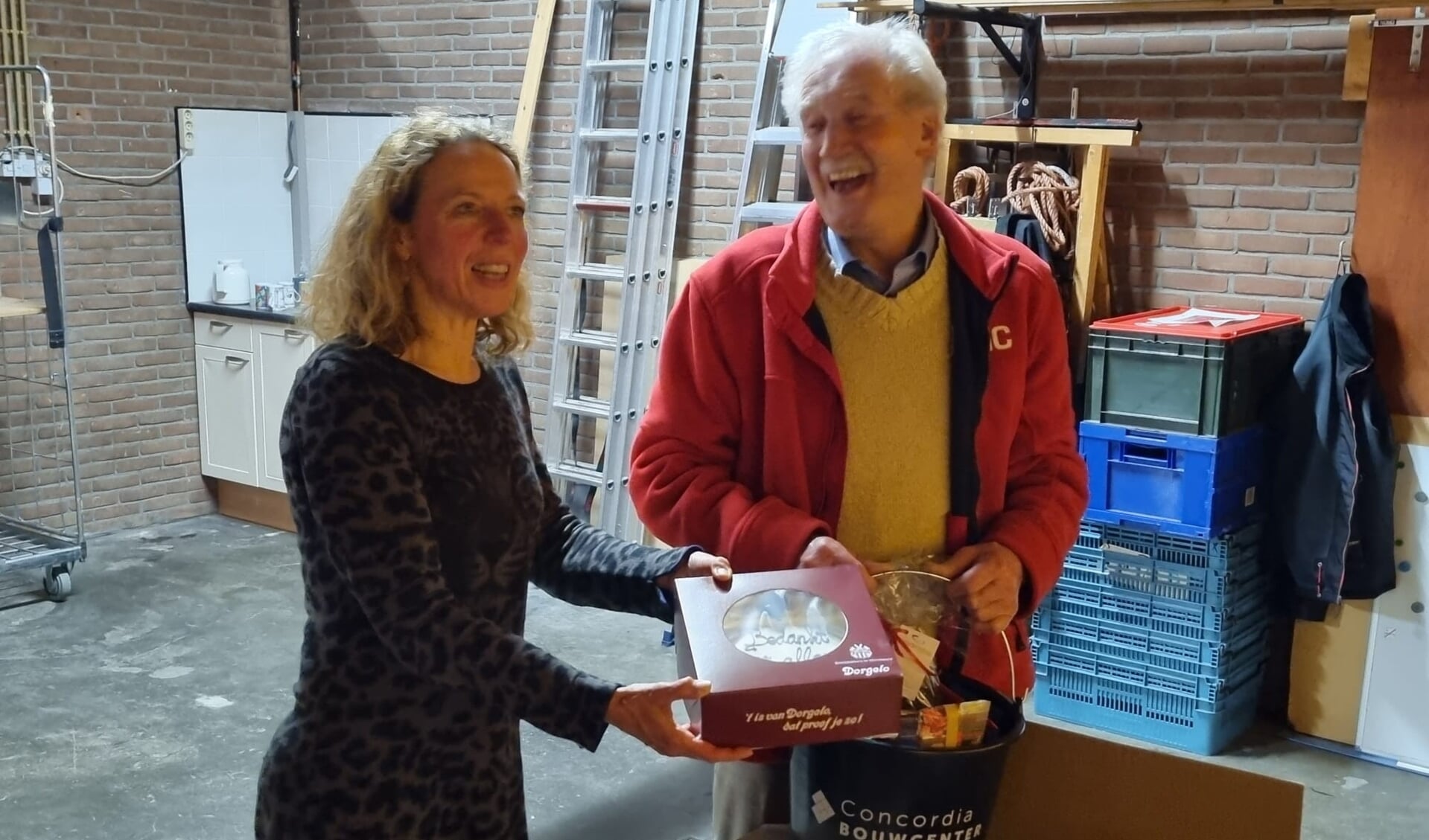 DMC-voorzitter Jolande Nanning reikt het eerste kerstpakket uit aan Gerrit Timmerman. 