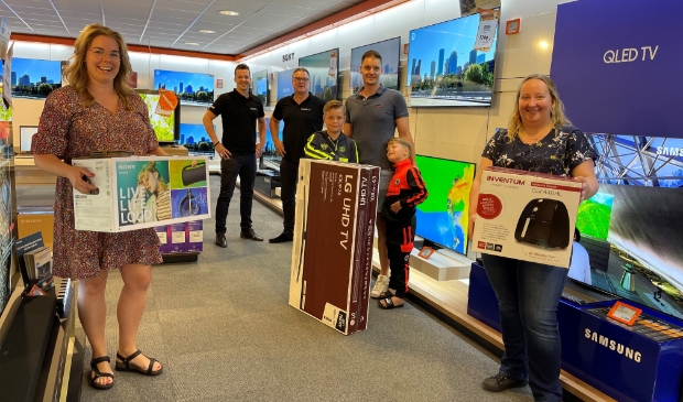 <p>Arjan Berkhof en Jordy Fraterman van Expert uit Vroomshoop met de winnaars van de EK-pool.</p>