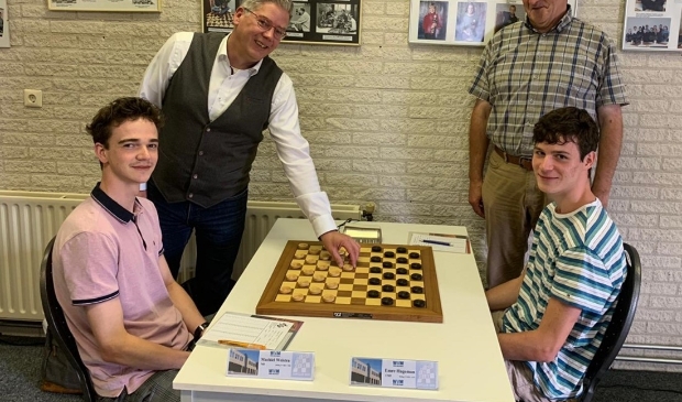 <p>Wethouder Mark Pater met de eerste zet op het bord van titelverdediger Machiel Weistra (links).</p>