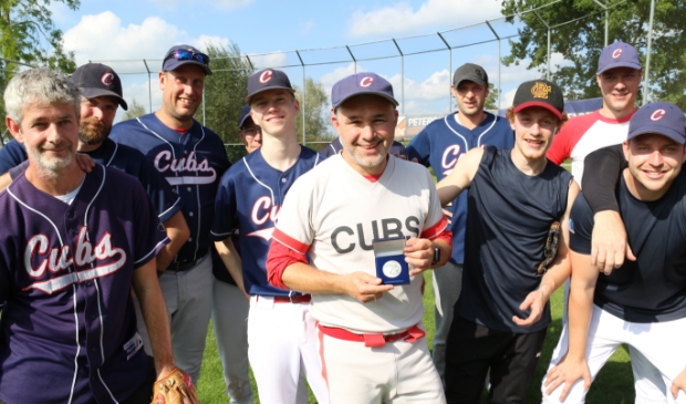 <p>Martijn Hartgerink (midden) van de Hardenberg Cubs toont de eremedaille van de KNBSB, die hij kreeg als dank voor zijn inzet voor de vereniging en de honkbalsport. </p>