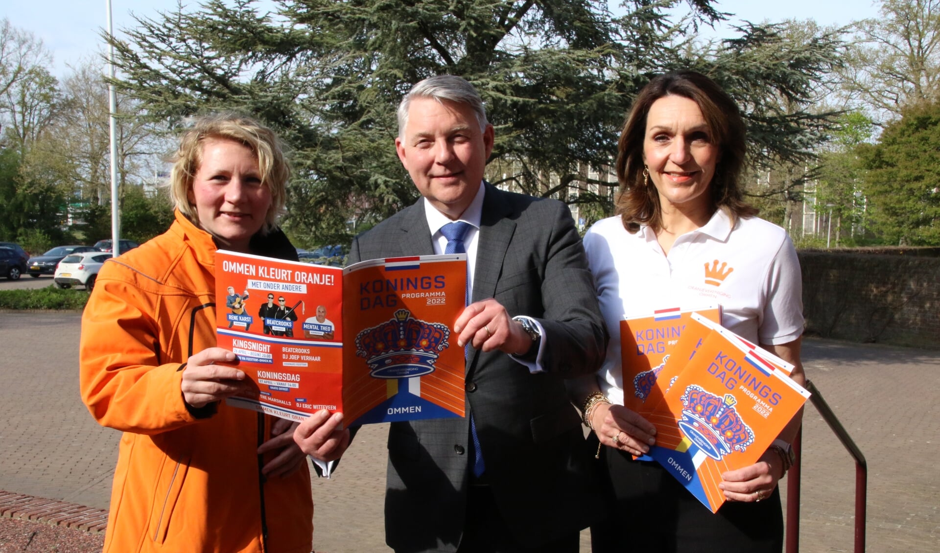 Madelon van Miltenburg (links) burgemeester Vroomen en Alice van den Nieuwboer presenteren het programma van de Oranjevereniging Ommen.