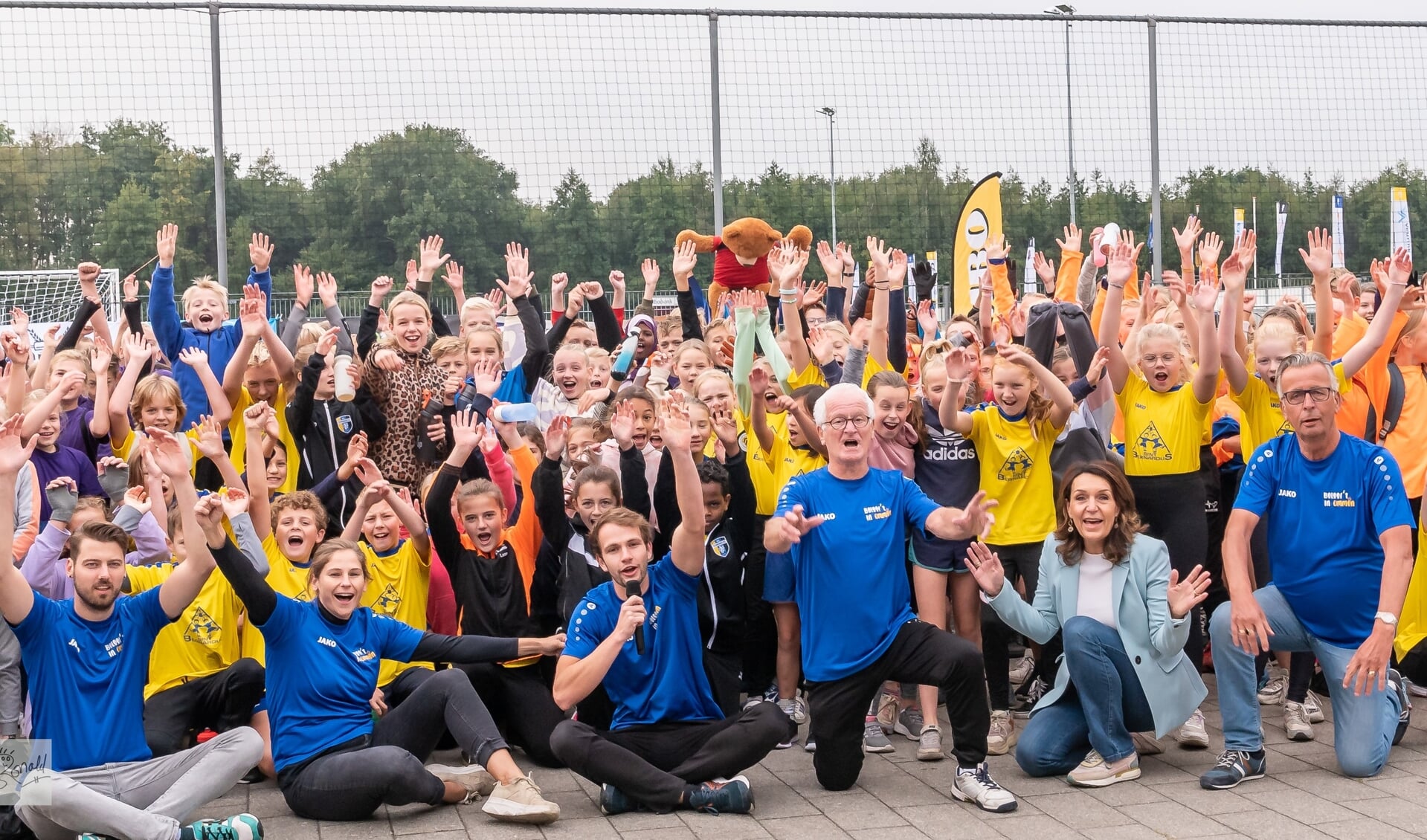 Op de achtergrond de deelnemende kinderen. Op de voorgrond vlnr.: Jordy Habekotte, Nienke Weideman, Jari Kouwen, Henk Kampman, wethouder Alice van den Nieuwboer, Bram Hoving. 