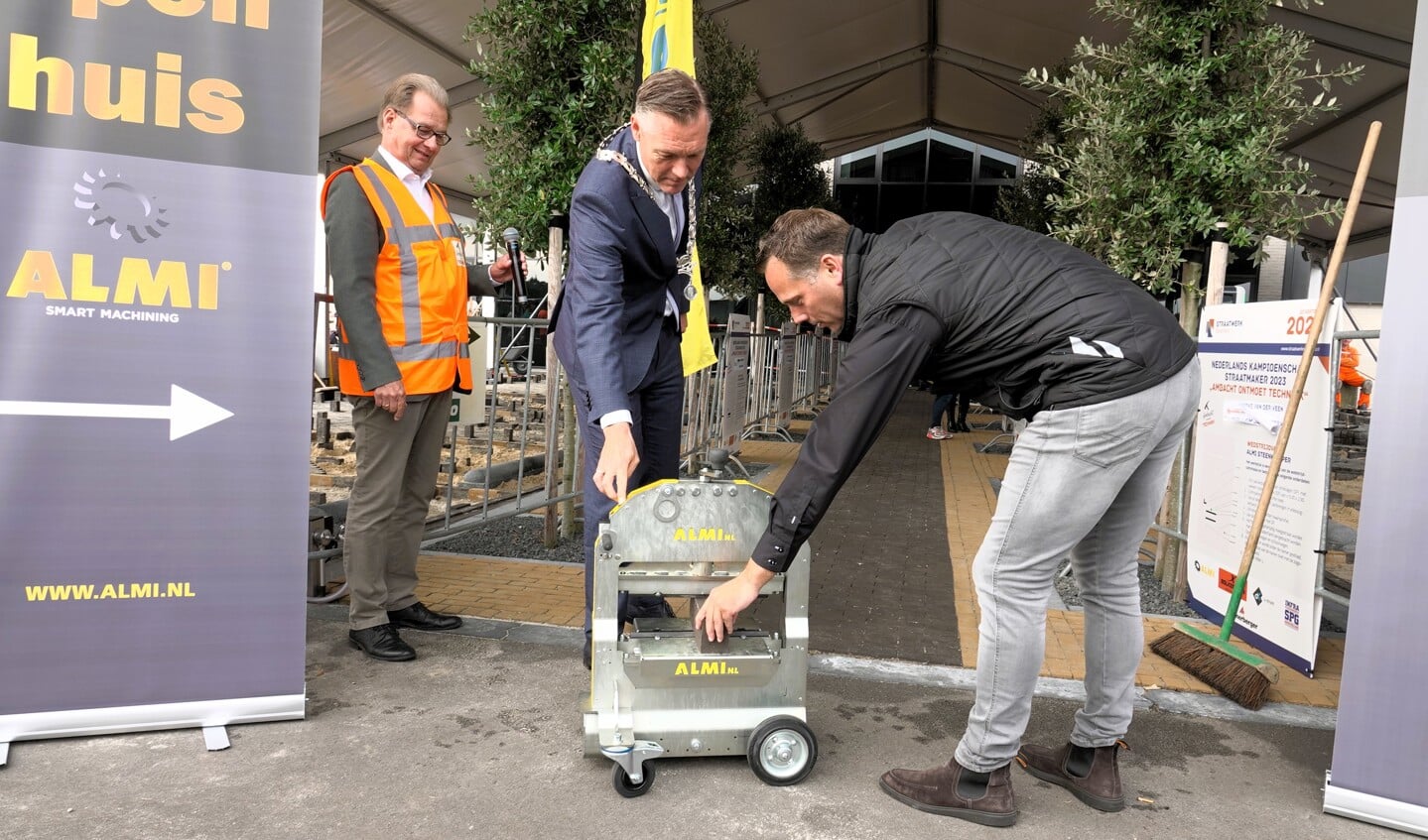 Burgemeester Hans Broekhuizen opende 'Ambacht ontmoet Techniek' middels het knippen van een steen.(Foto: Gert Stegeman).