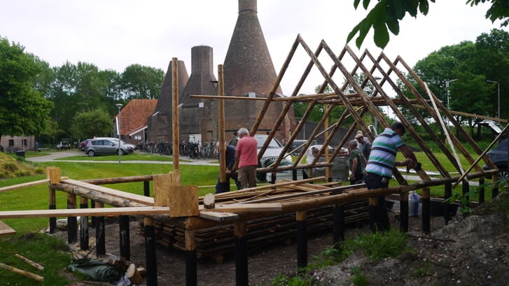 Vrijwilligers van de Historische Vereniging Avereest werken hard aan de bouw van een replica van een plaggenhut in Dedemsvaart. 