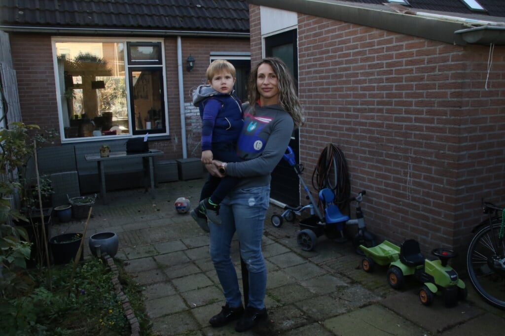 Kristyna met haar twee jarige zoon in de krappe achtertuin. 