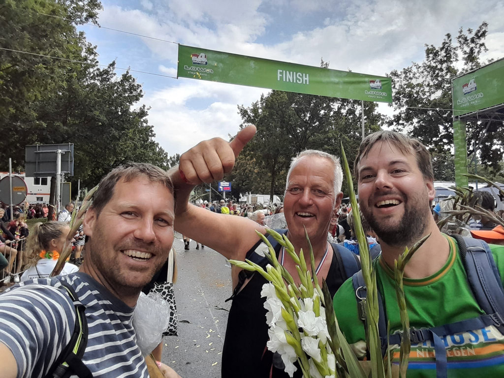 Mark Bosman, Marcel Bosman en Rob Nijkamp (v.l.n.r.) vieren hun overwinning nadat ze de Nijmeegse Vierdaagse voltooiden.