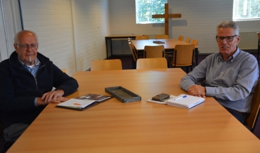Voorzitter Theo Koele (r.) en coördinator  Hans van Leeuwen van Schuldhulpmaatje Oldebroek overleggen op gepaste afstand. (Foto: Dick van der Veen)