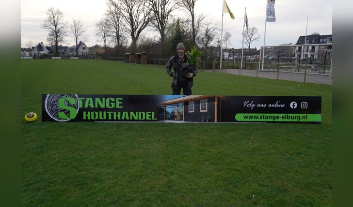Sander Stange met het nieuwe reclamebord van zijn Stange Houthandel op sportpark De Heughte van VSCO'61