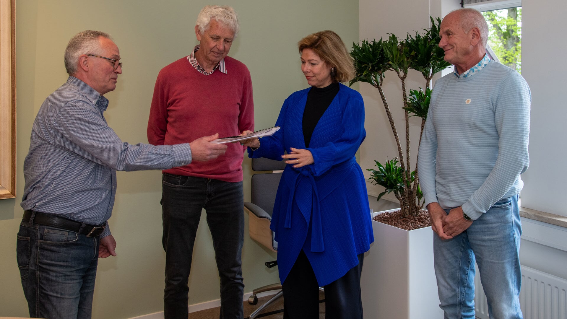 Henk Hagen, Klaas van Harten en Hans Goes bieden het zwartboek aan burgemeester Celine Blom aan. 