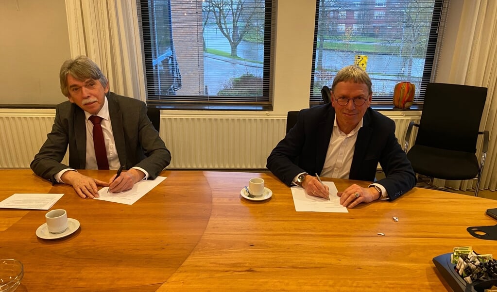 Burgemeester Gerard Beukema (links) en Fester Oosterhuis zetten hun handtekening.