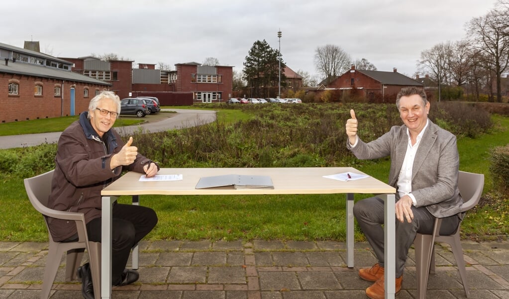 Wethouder Pier Prins (links) en Wierden en Borgen-bestuurder Matthieu van Olffen ondertekenen de intentieovereenkomst met op de achtergrond het Lopster gemeentehuis.