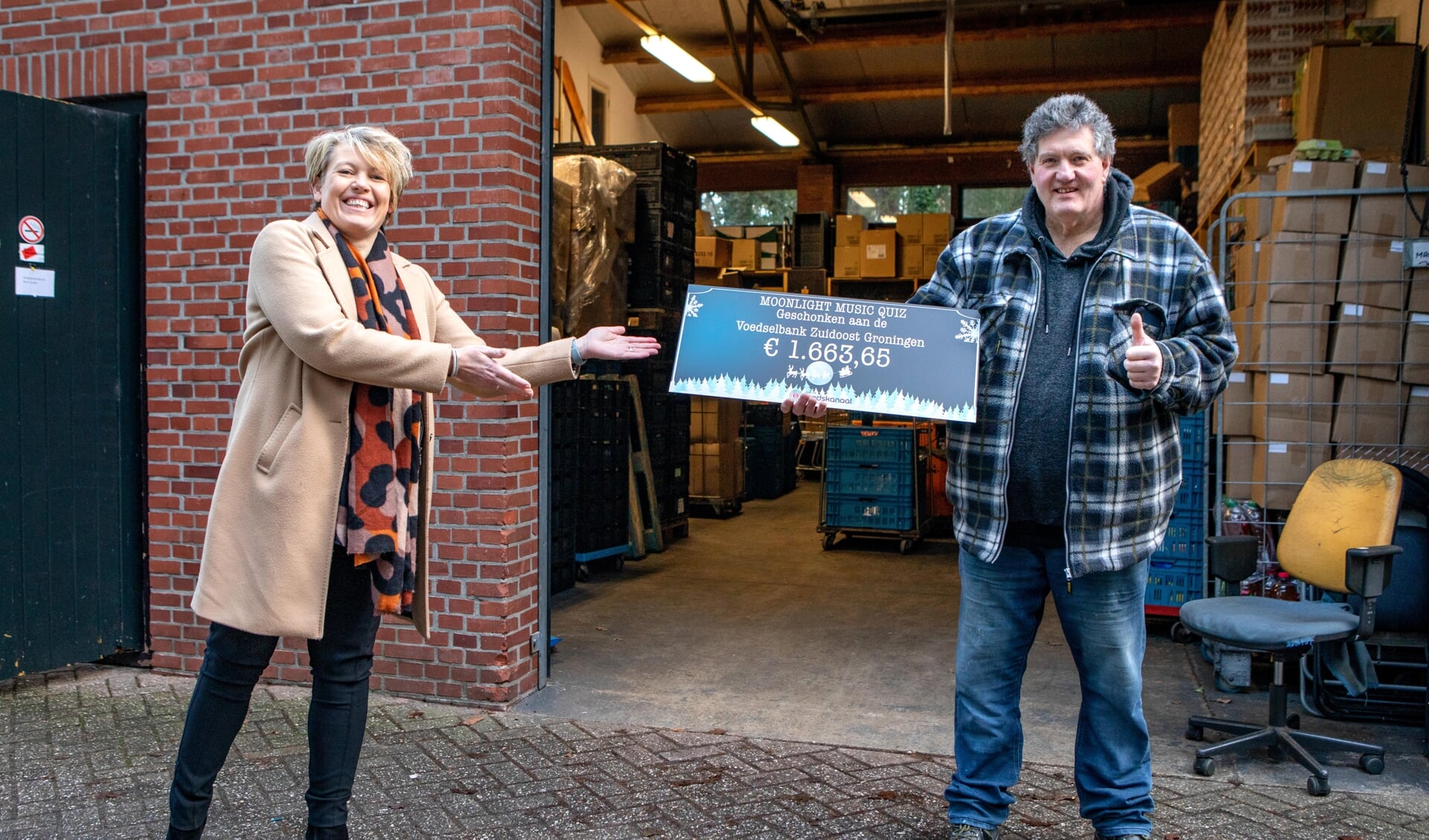 Jessica Looden overhandigt de cheque aan Willem van Veen van de Voedselbank Zuidoost Groningen.