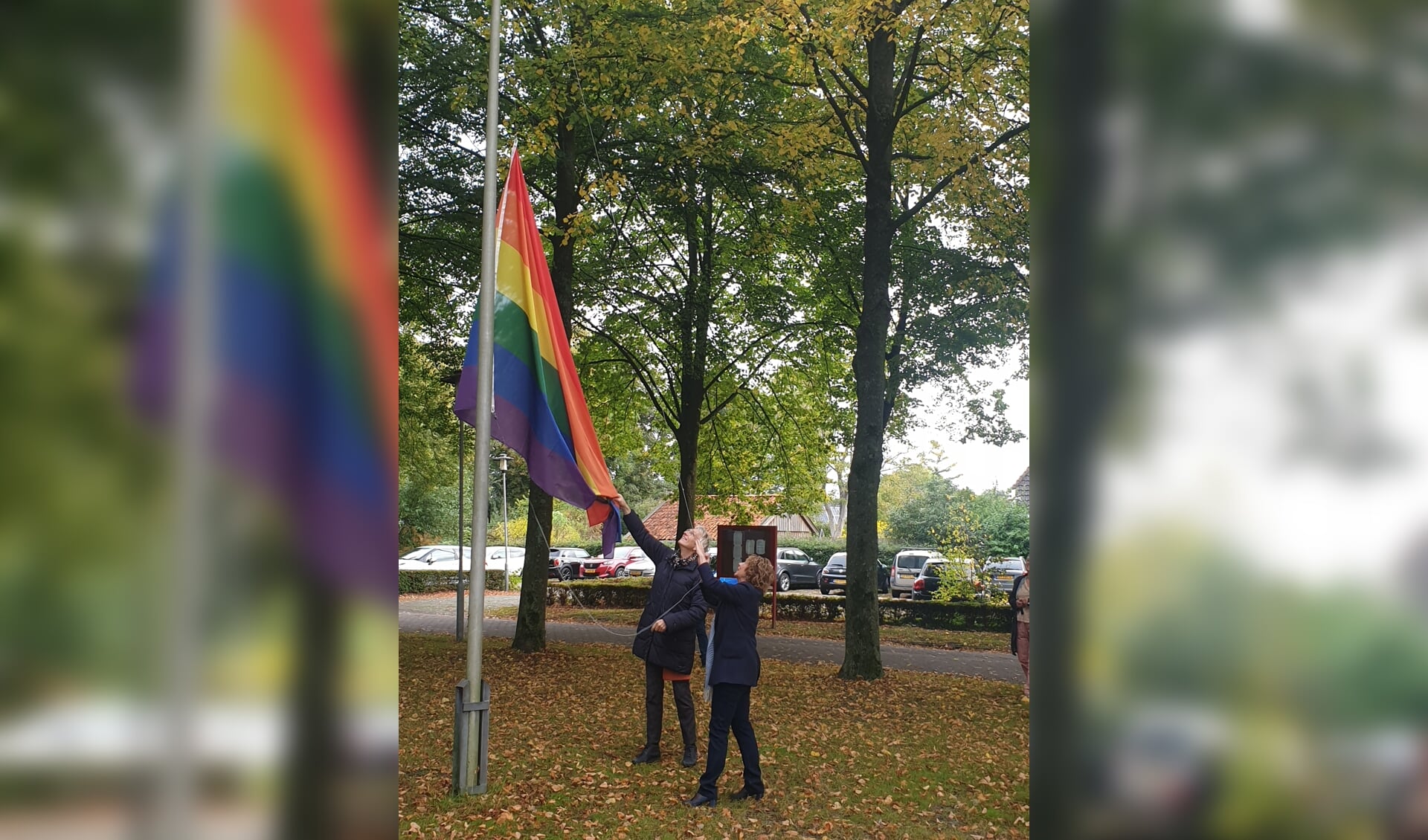 Wethouder Giny Luth hijst samen met Willemijn Ahlers de regenboogvlag. (foto: gemeente Westerwolde)