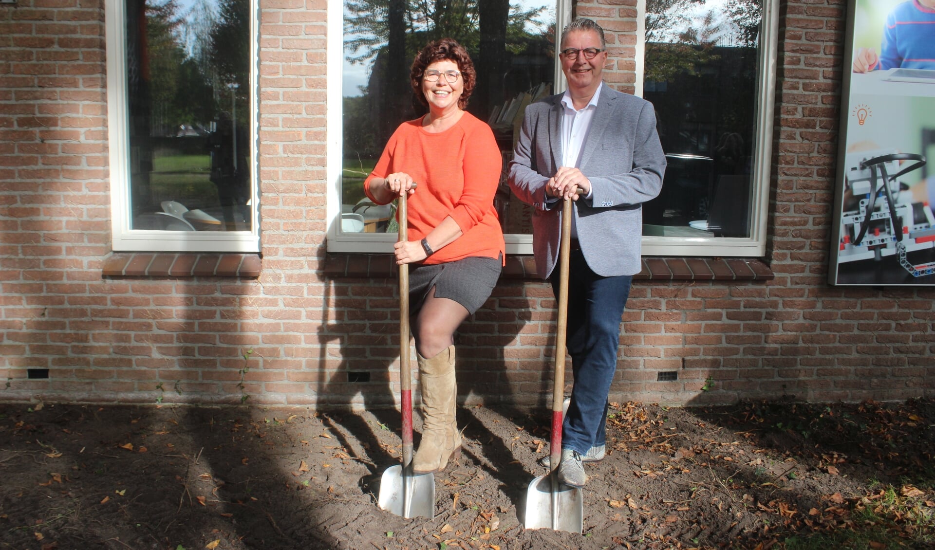Bilbliotheekmanager Lammie van der Tuuk en wethouder Bas Luinge van Aa en Hunze zetten de eerste schop in de grond van de nieuwe bibliotheektuin. 