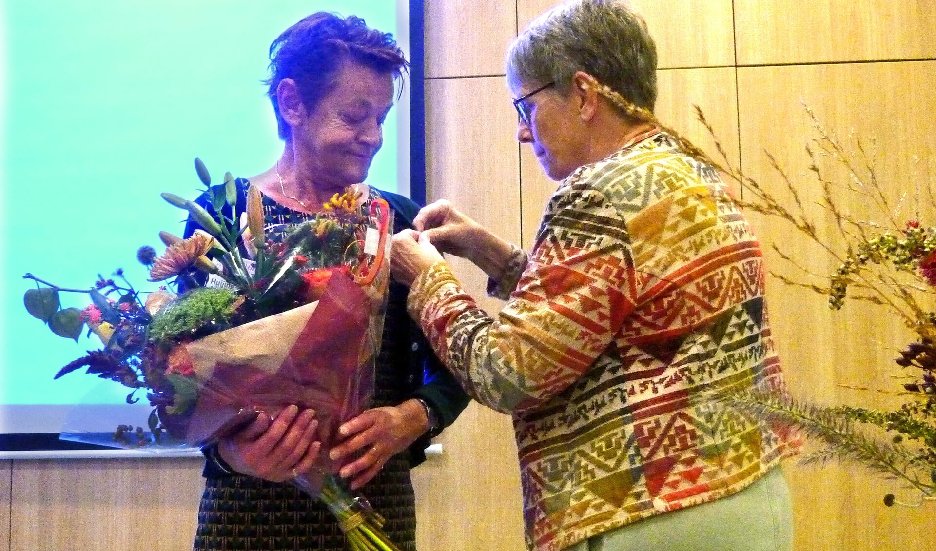 Berta Huijing ontvangt de gouden erespeld van Jolanda Schoenmaker (foto Wim Poll).