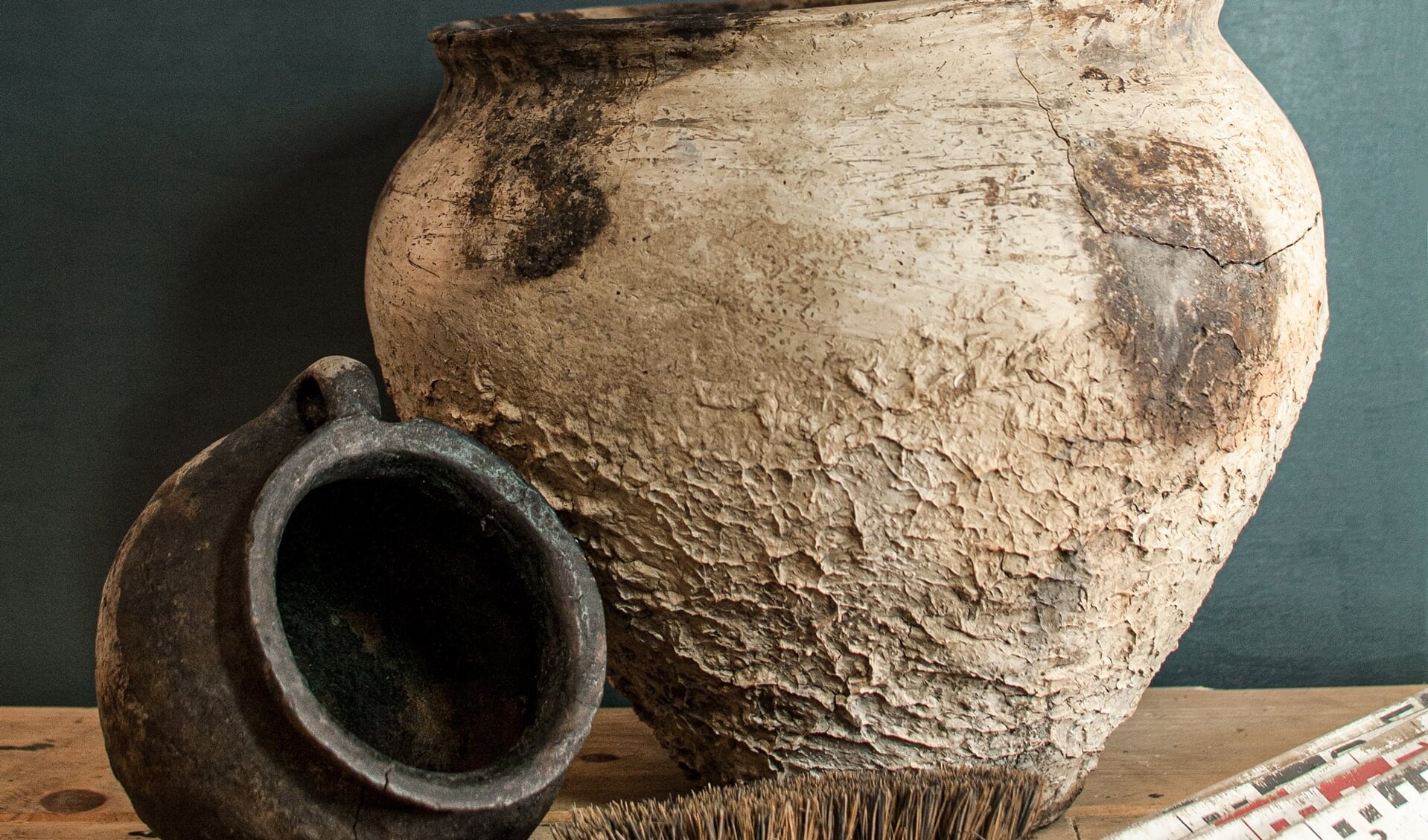 Een grote pot en pot met oor uit de eerste of tweede eeuw na Christus, gevonden in Adorp. Foto onder: een Romeinse mantelspeld. Foto’s: MUG Ingenieursbureau. 