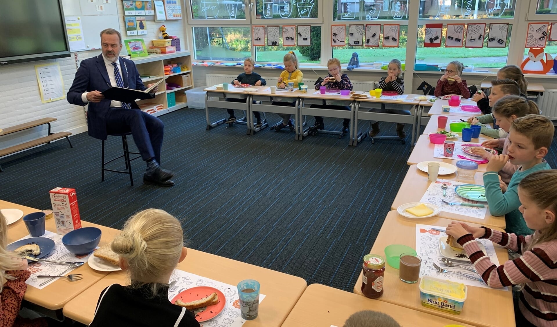 Burgemeester Sloots leest de kinderen van groep 3 en 4 voor. (foto: Piet Prinsschool)