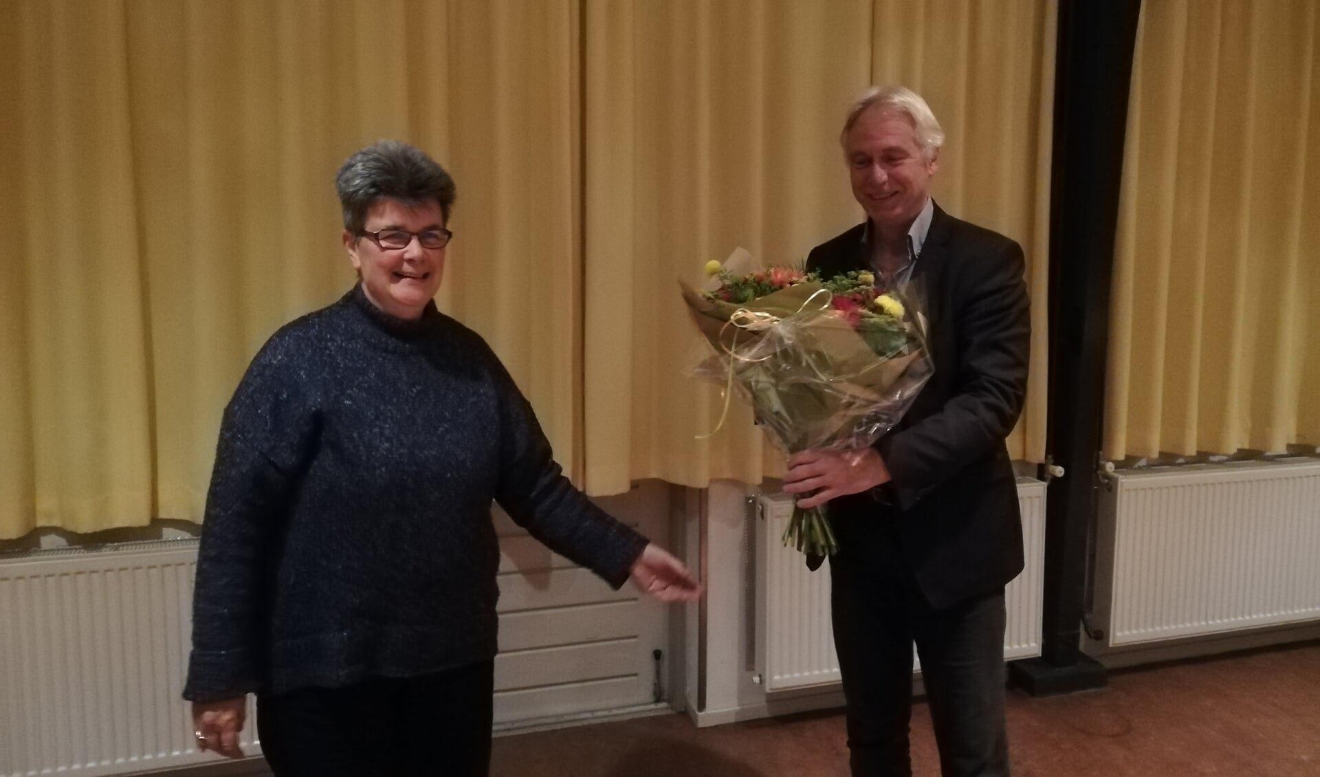 De nieuwe lijsttrekker Lukas Koops krijgt de bloemen overhandigd door fractievoorzitter Marie-Claire Neesen. (foto: GroenLinks Aa en Hunze)