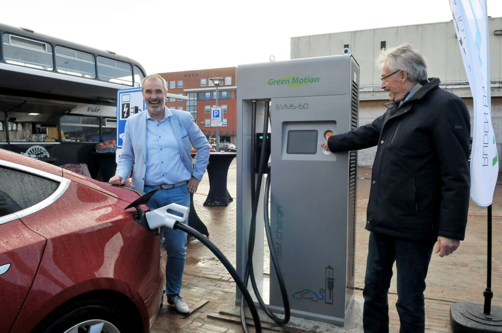 Hans Ronde en Jan Menninga sluiten de eerste auto aan op de snelle laadpaal.