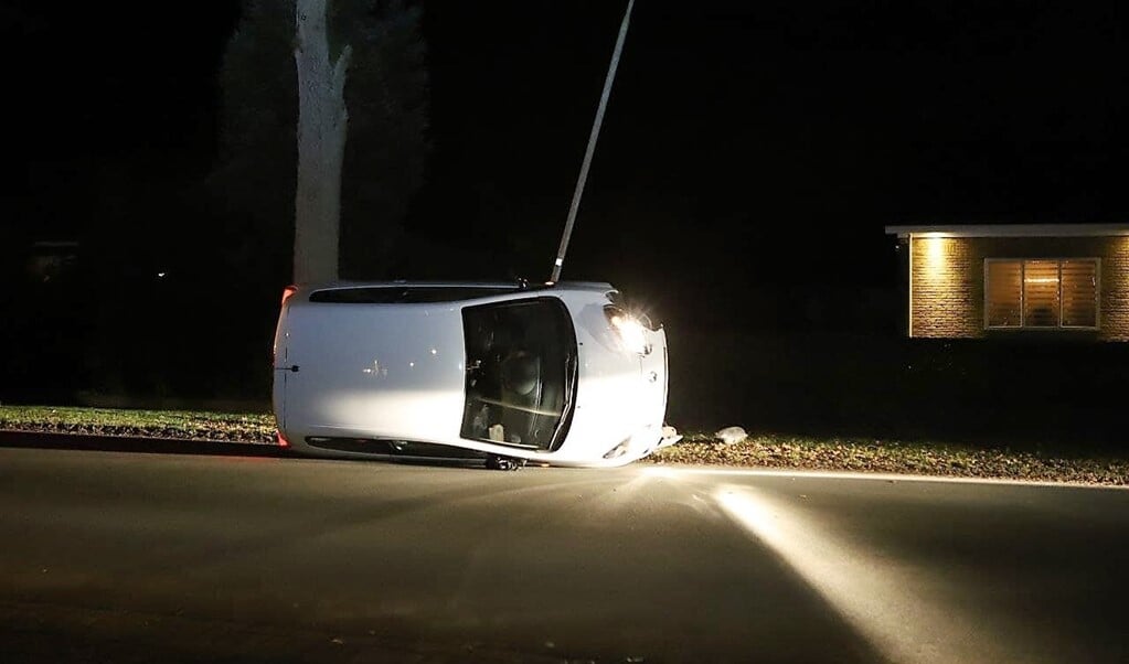 De auto kwam na de botsing met de lantaarnpaal op zijn kant terecht. (foto: Persbureau Drenthe)
