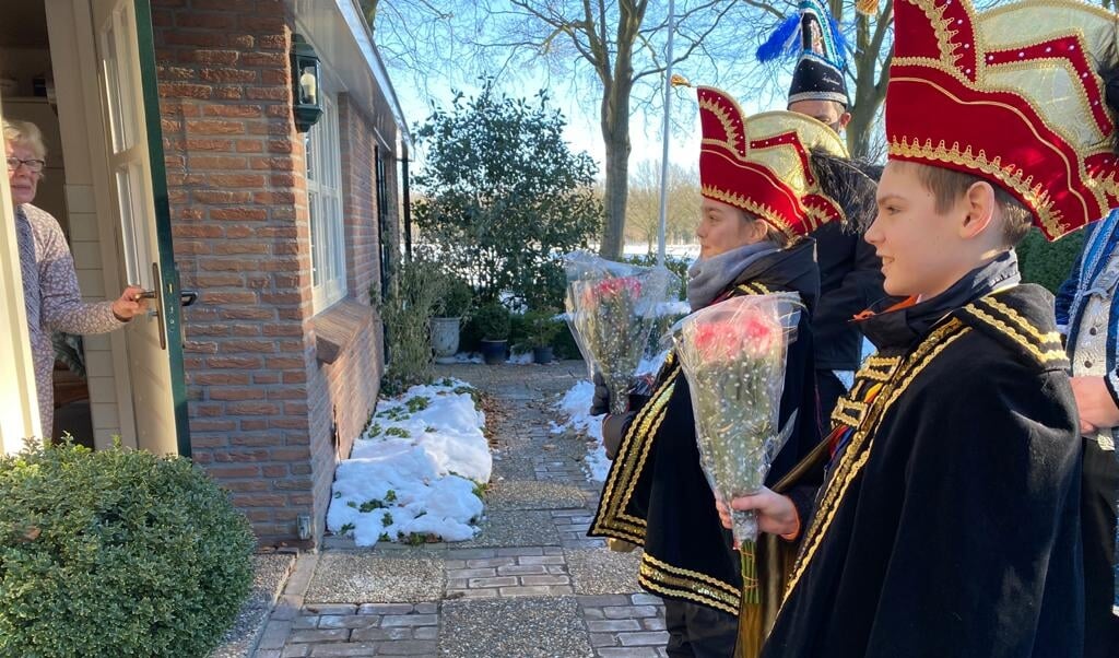Carnavalsvereniging Meul'ndobbegie biedt een inwoonster van Gasselte een bos bloemen aan. (eigen foto)