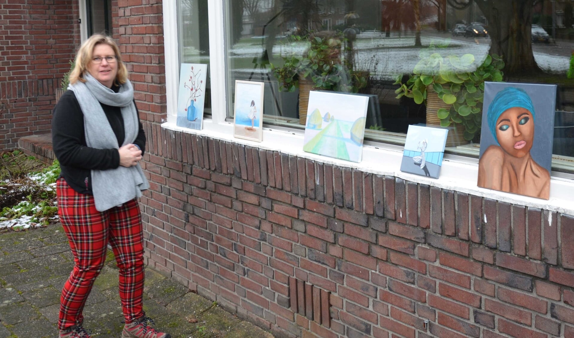 Initiatiefneemster en buurtcomitélid Astrid Boekholt met een aantal van haar schilderijen.