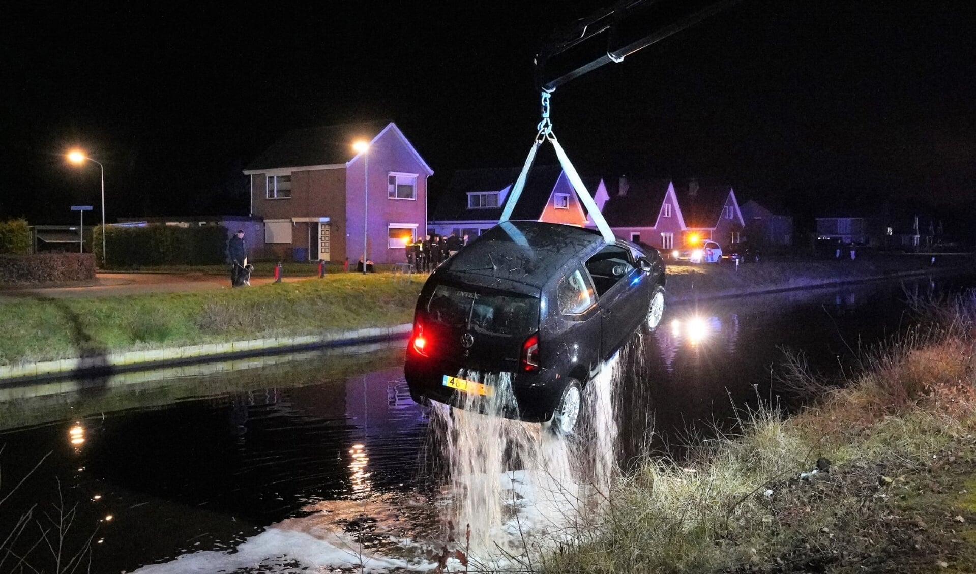 De auto wordt uit het kanaal getakeld (foto Van Oost Media).