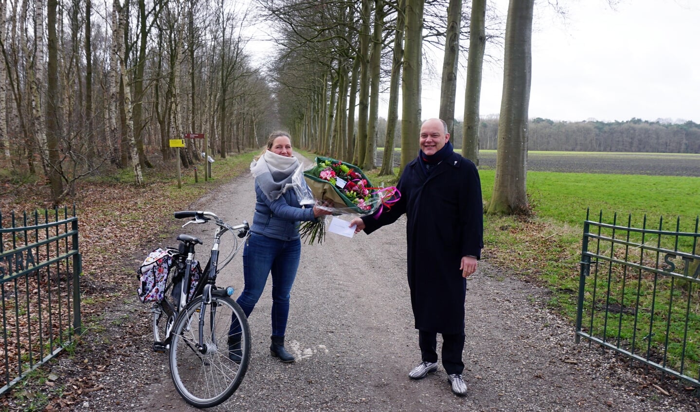 Marieke Hazewinkel ontvangt de cadeaubon en het bloemetje uit handen van wethouder Jan Batelaan (foto Gemeente Midden-Drenthe).