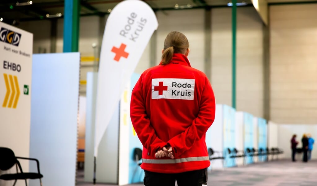 Een medewerker van het Rode Kruis houdt toezicht bij een vaccinatielocatie. (foto Bart Hoogveld)