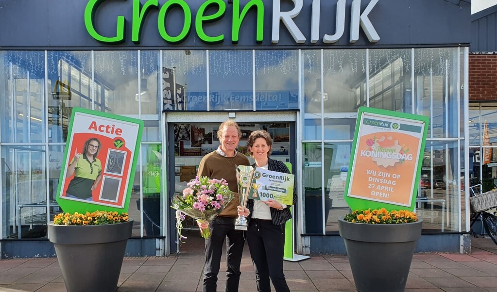 Ondernemers André en Emme de Vries met de trofee en bloemen. 