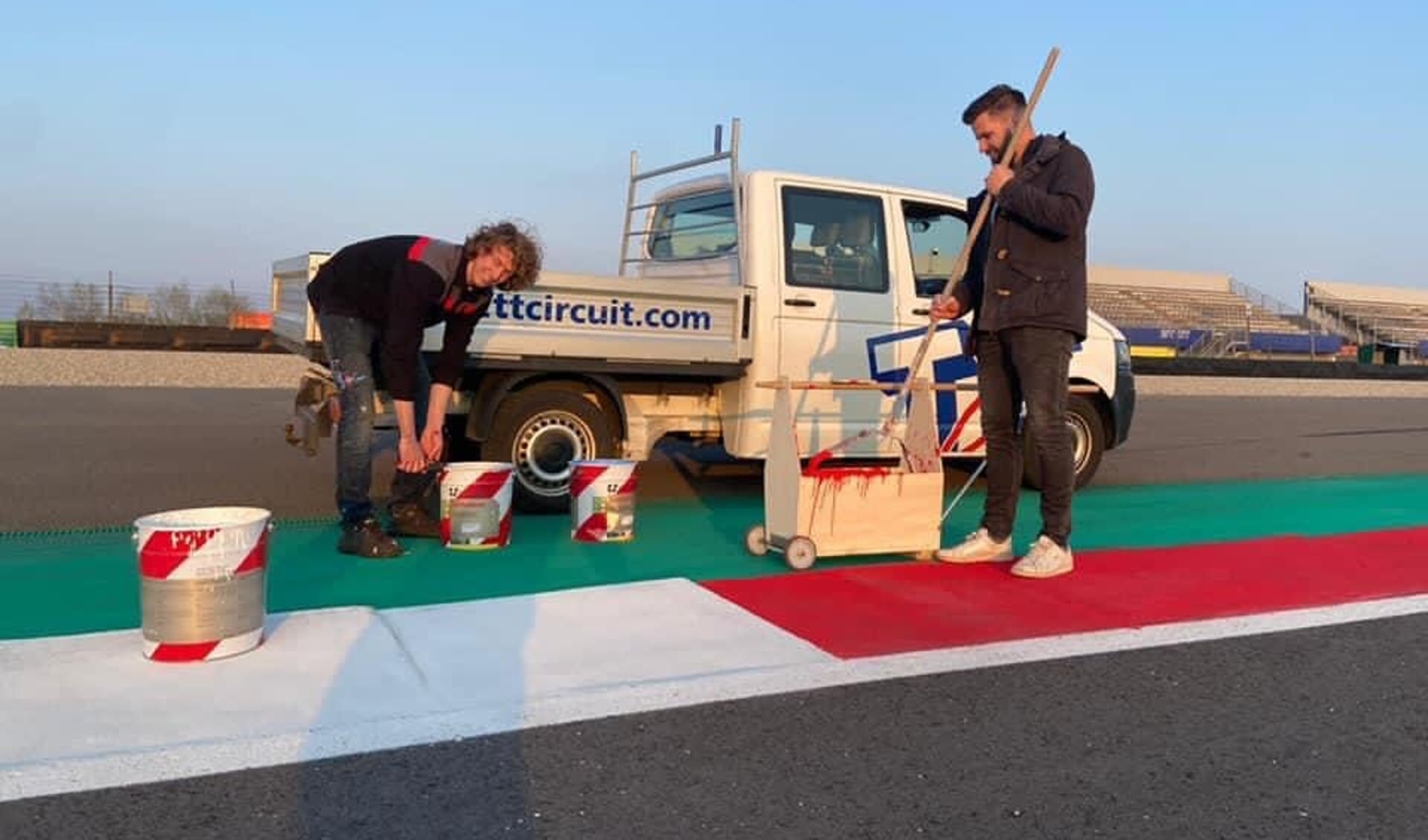 Vrijwilligers van VV Annen schilderen de kerbstones langs het TT Circuit.