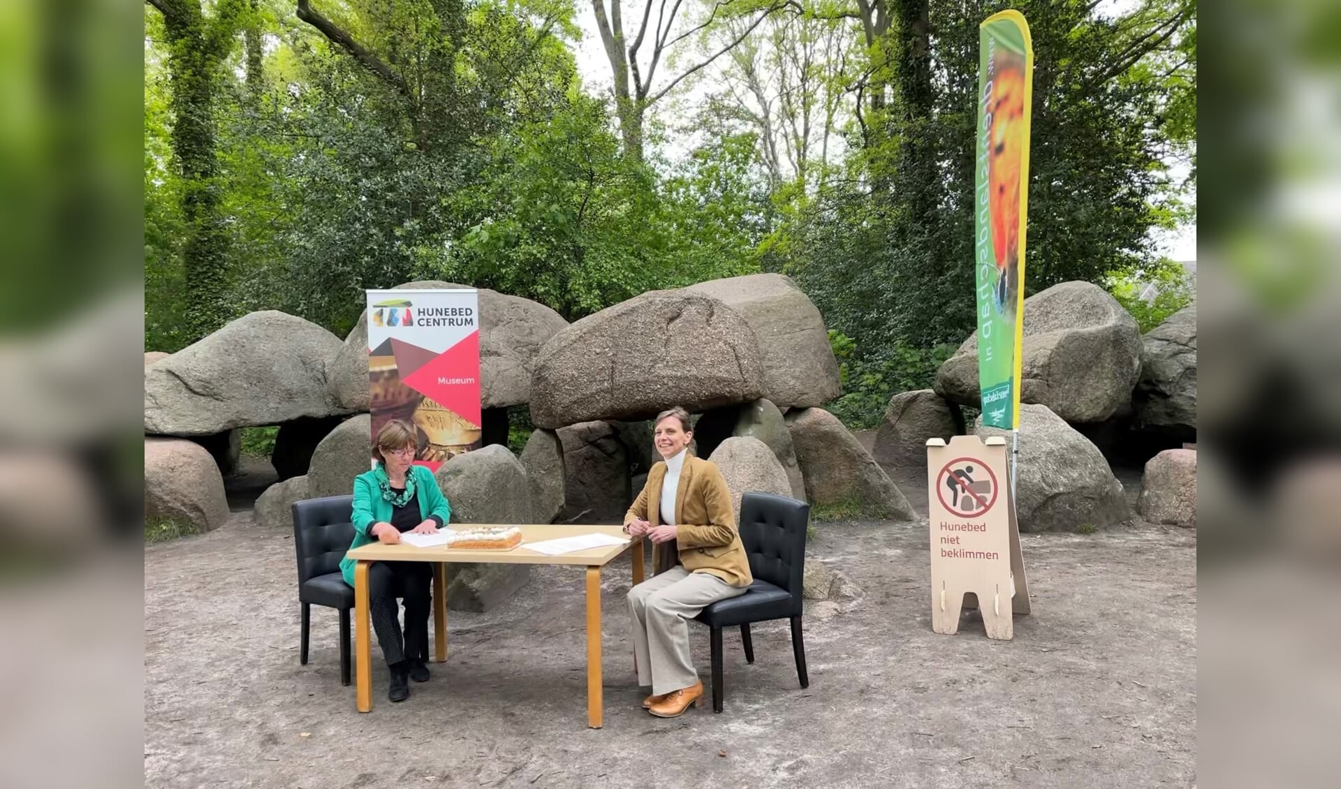 Tryntsje Slagman (links) en Sonja van der Meer (rechts) ondertekenen het convenant bij Hunebed D27. (foto: Het Drentse Landschap/Paulien Zomer)