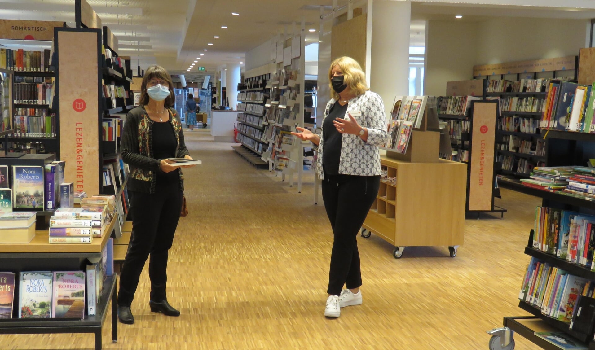 Janneke Klok (rechts) geeft wethouder Van Schie uitleg over de nieuwe bibliotheek.