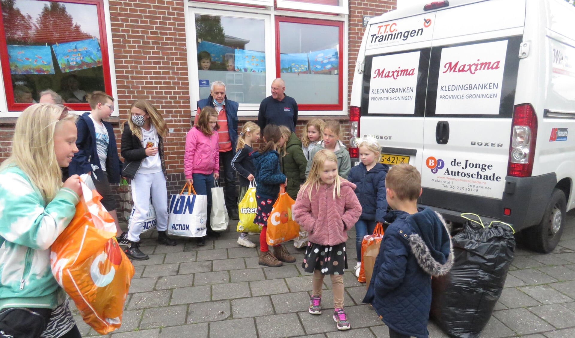 Kinderen van CBS De Parel overhandigen de ingezamelde kleding aan Kledingbank Maxima.