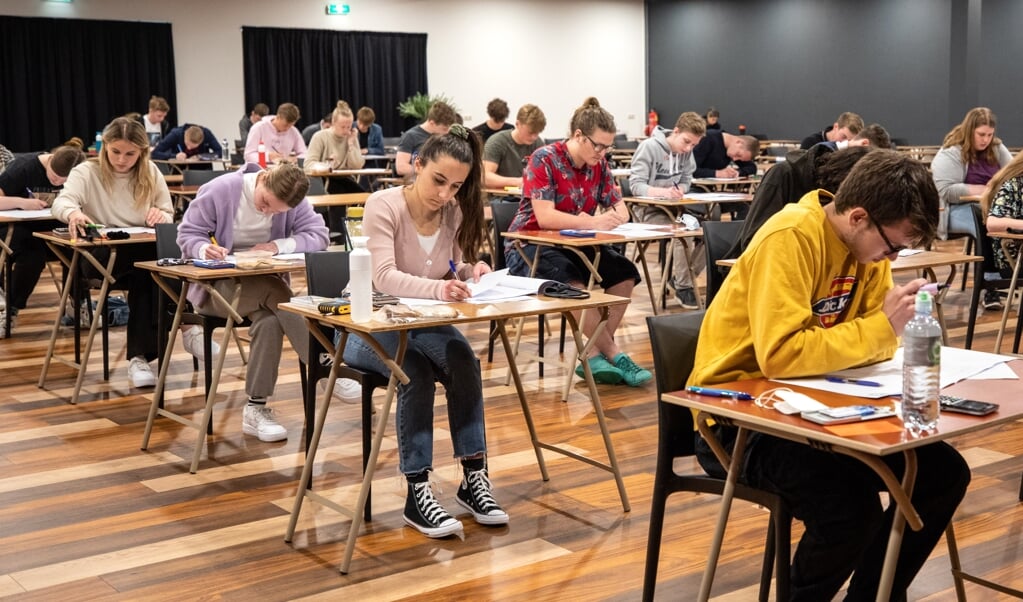 De leerlingen van het Ubbo Emmius buigen zich over hun eerste examen in de Pleinzaal van Theater Geert Teis. (foto: Auniek Klijnstra)