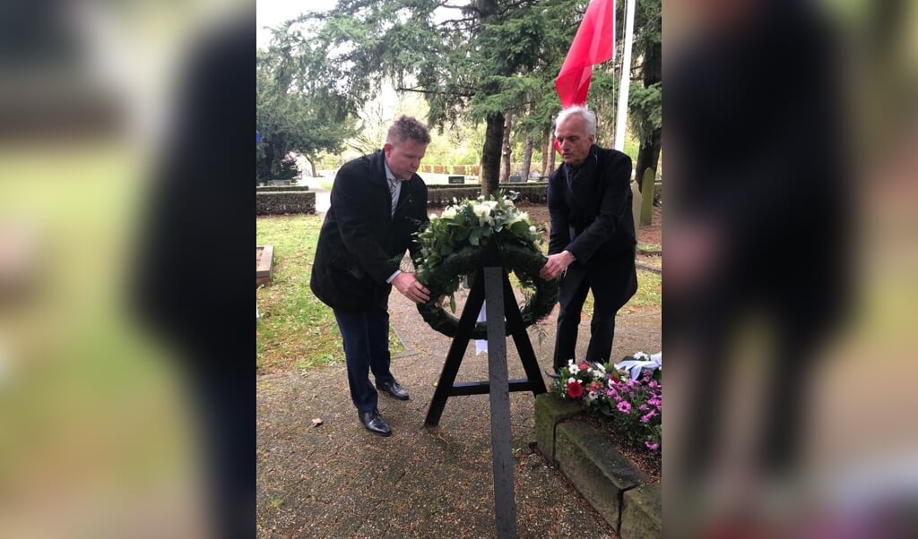 Wethouder Robert Kleine en D66-raadslid Karel Eggen leggen een krans op de begraafplaats in Nieuw-Weerdinge (foto Gemeente Emmen).