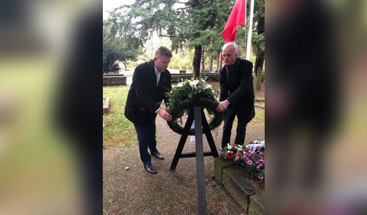 Wethouder Robert Kleine en D66-raadslid Karel Eggen leggen een krans op de begraafplaats in Nieuw-Weerdinge (foto Gemeente Emmen).
