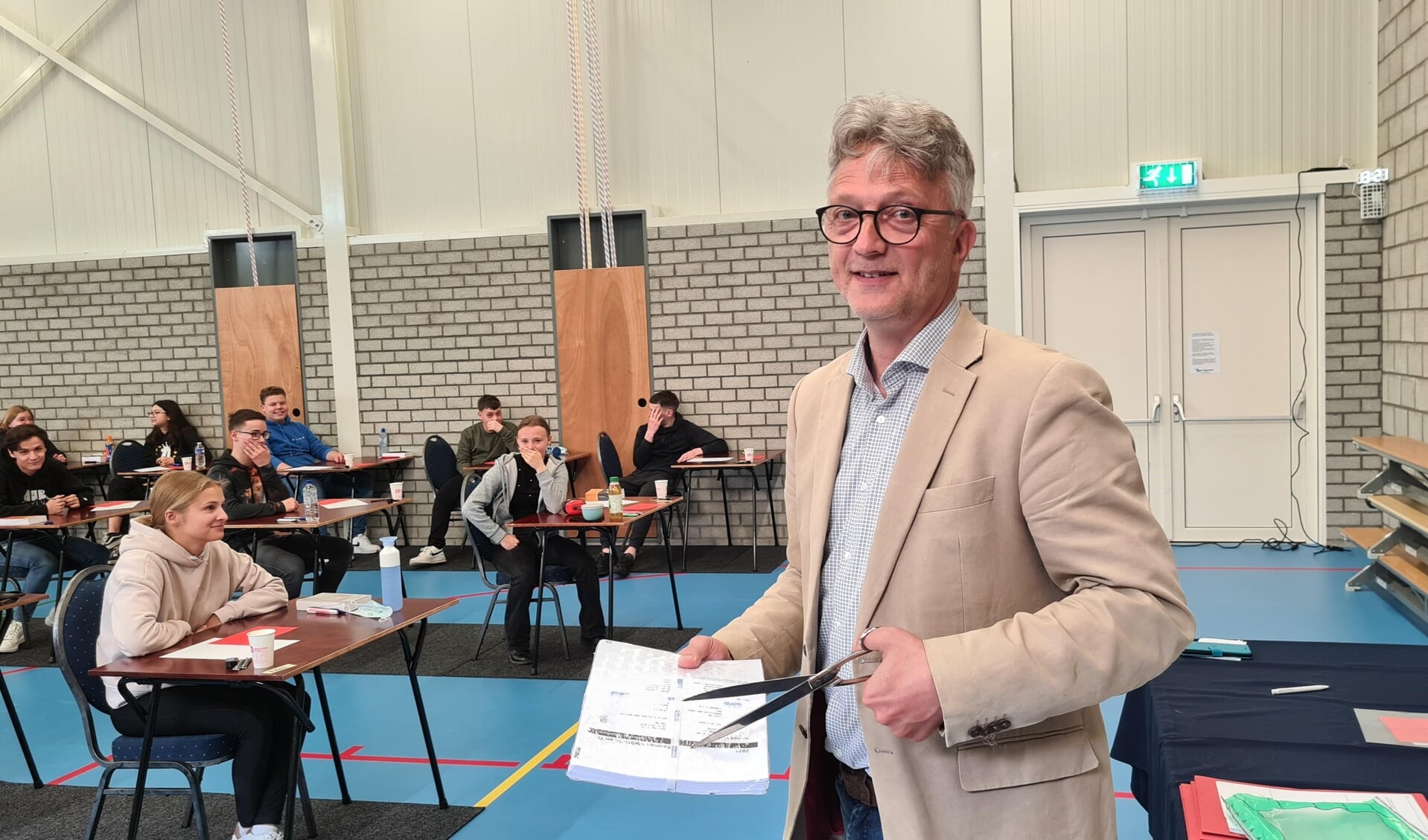 Directeur Wout Zilverberg opent de envelop met examenopgaven Nederlands mavo: de examens zijn begonnen.