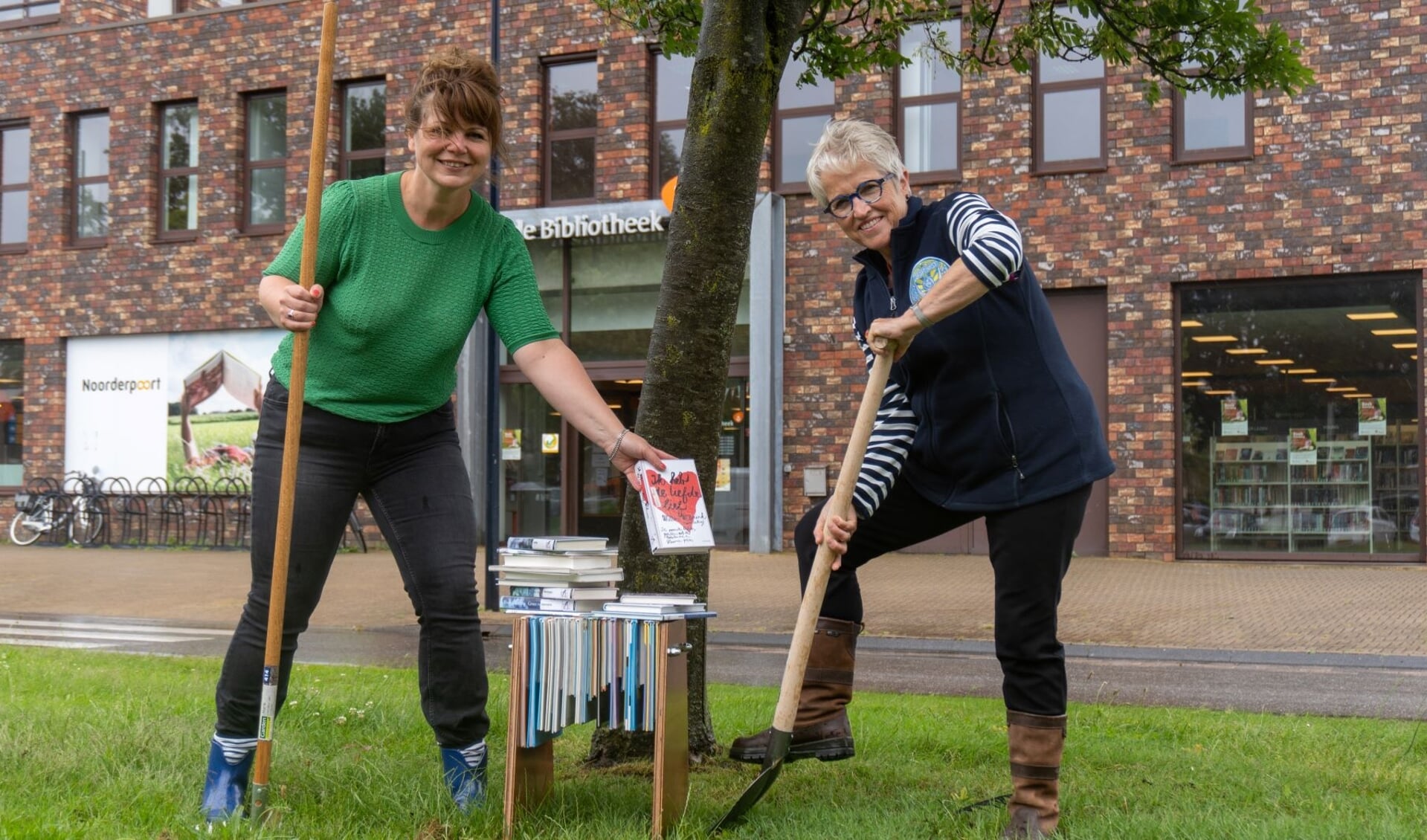 Harma de Roo (links) en Christina Klarenbeek planten symbolisch een boom voor de Bibliotheek Stadskanaal. (foto: Biblionet Groningen)