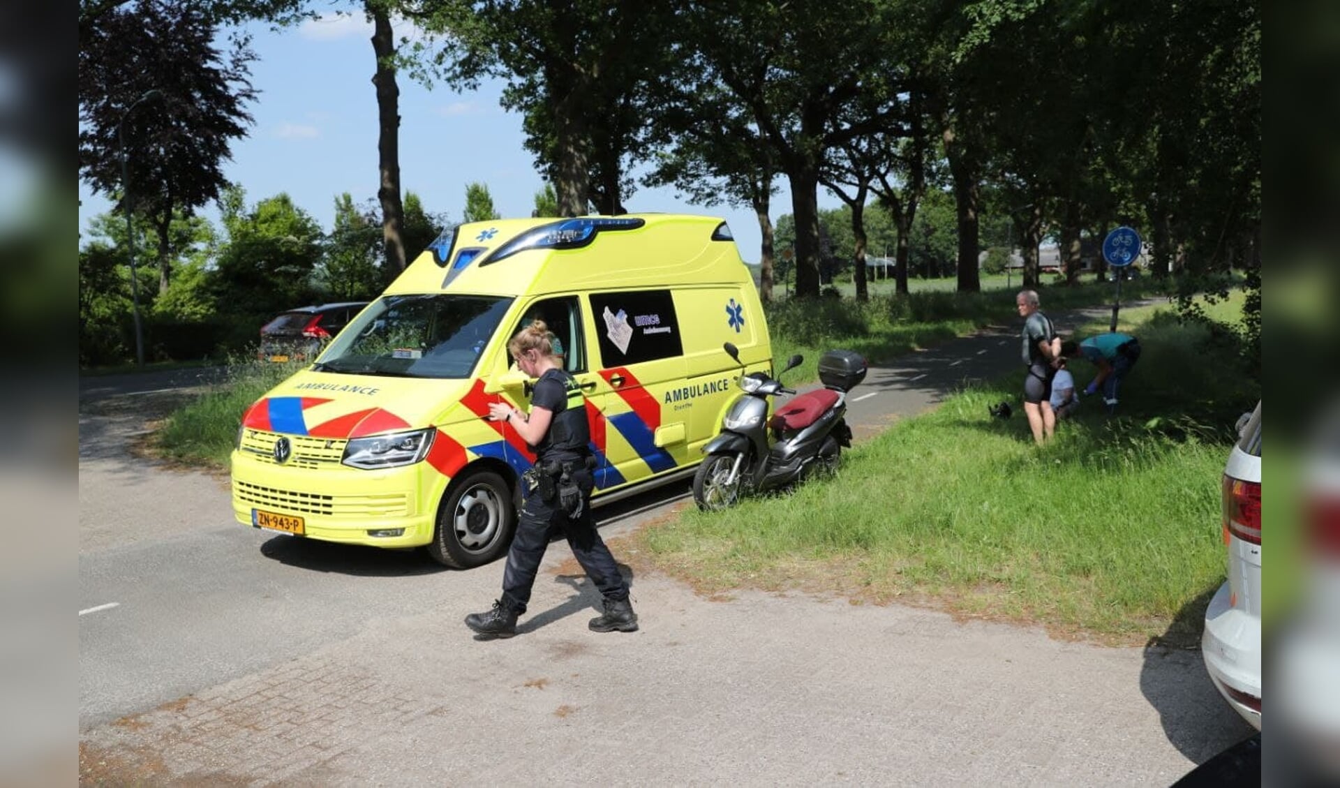 De aangereden scooterrijder wordt geholpen door de hulpdiensten.